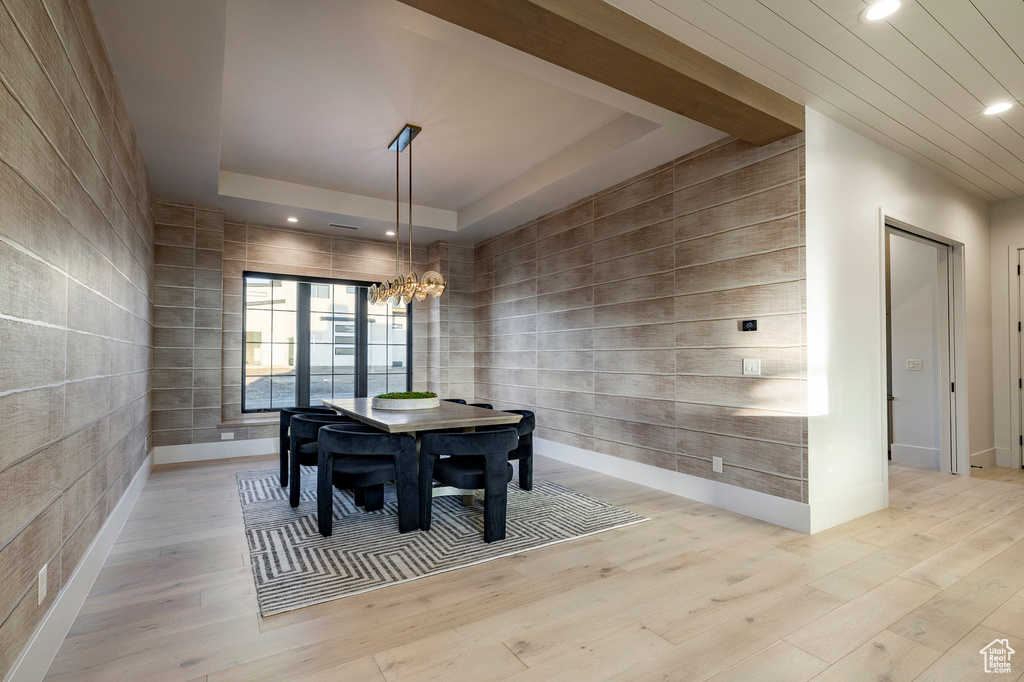 Dining area with recessed lighting, light wood-style flooring, and a raised ceiling