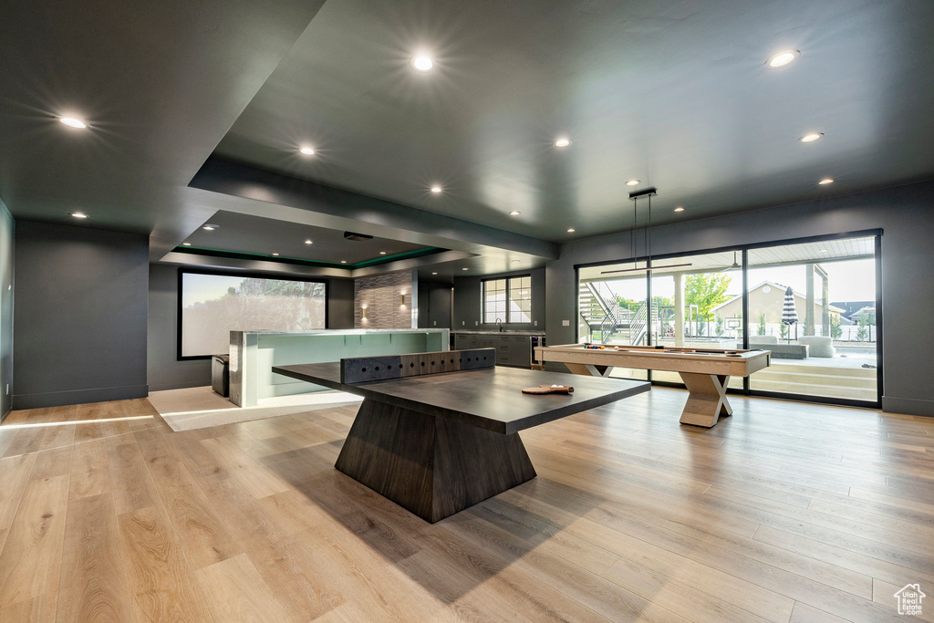 Kitchen with light wood-type flooring, recessed lighting, a sink, and dark countertops