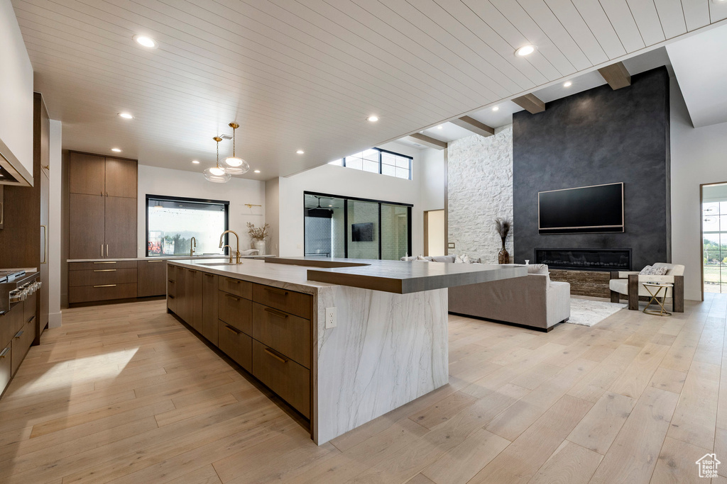 Kitchen featuring modern cabinets, open floor plan, a large island, a sink, and light wood-style floors