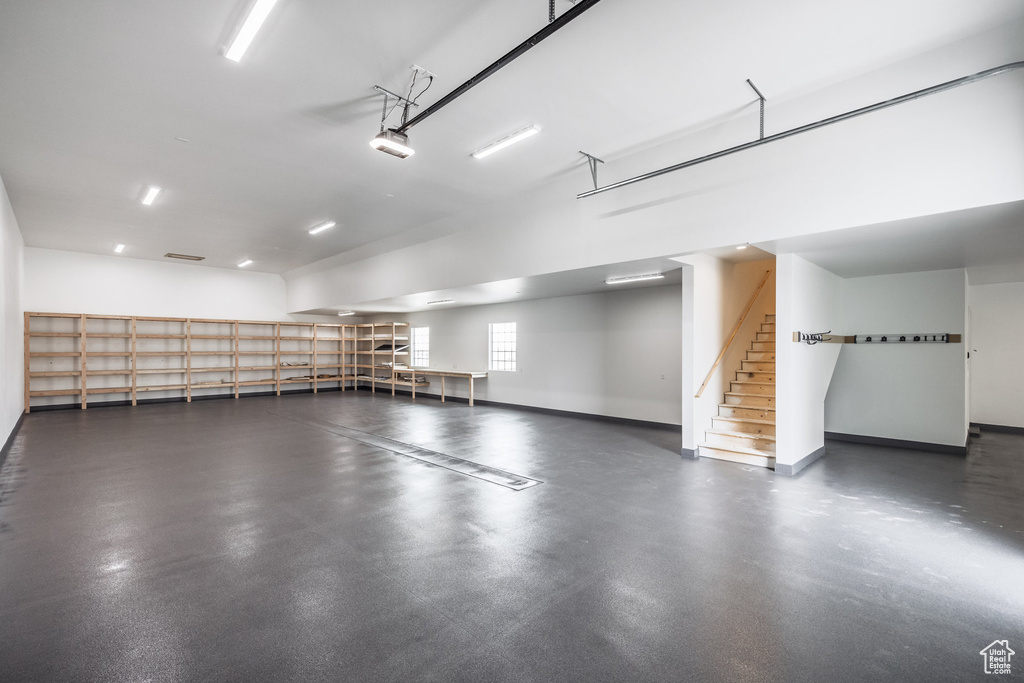 Garage featuring baseboards and a garage door opener