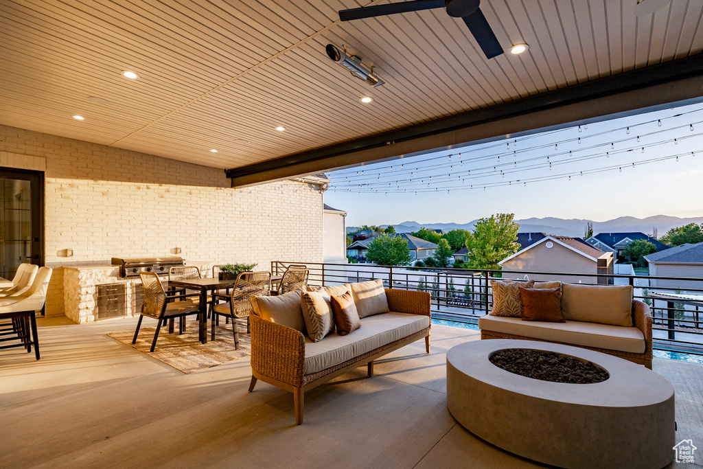 View of patio featuring a mountain view, a balcony, and an outdoor living space with a fire pit