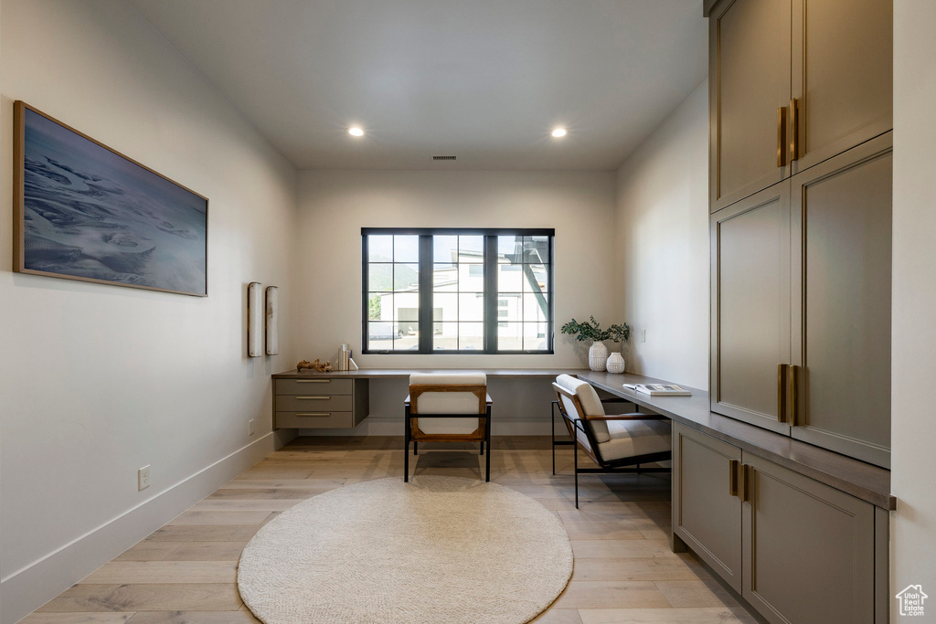 Office with built in study area, recessed lighting, light wood-style floors, and baseboards