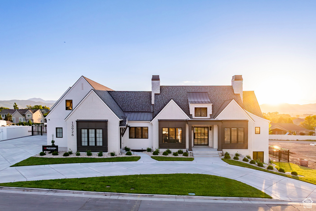 Modern farmhouse style home featuring a standing seam roof, a chimney, metal roof, and a mountain view