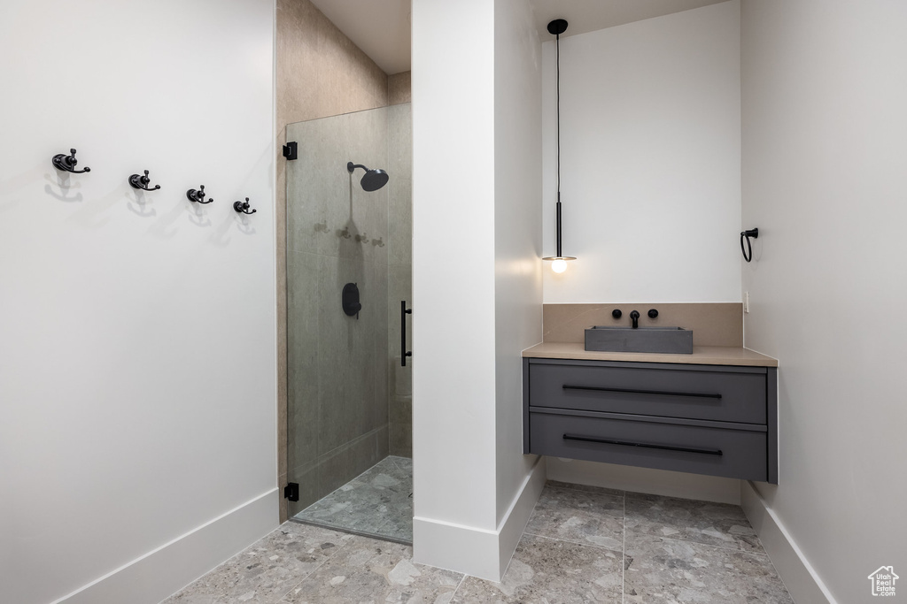 Full bath with baseboards, a sink, and a stall shower