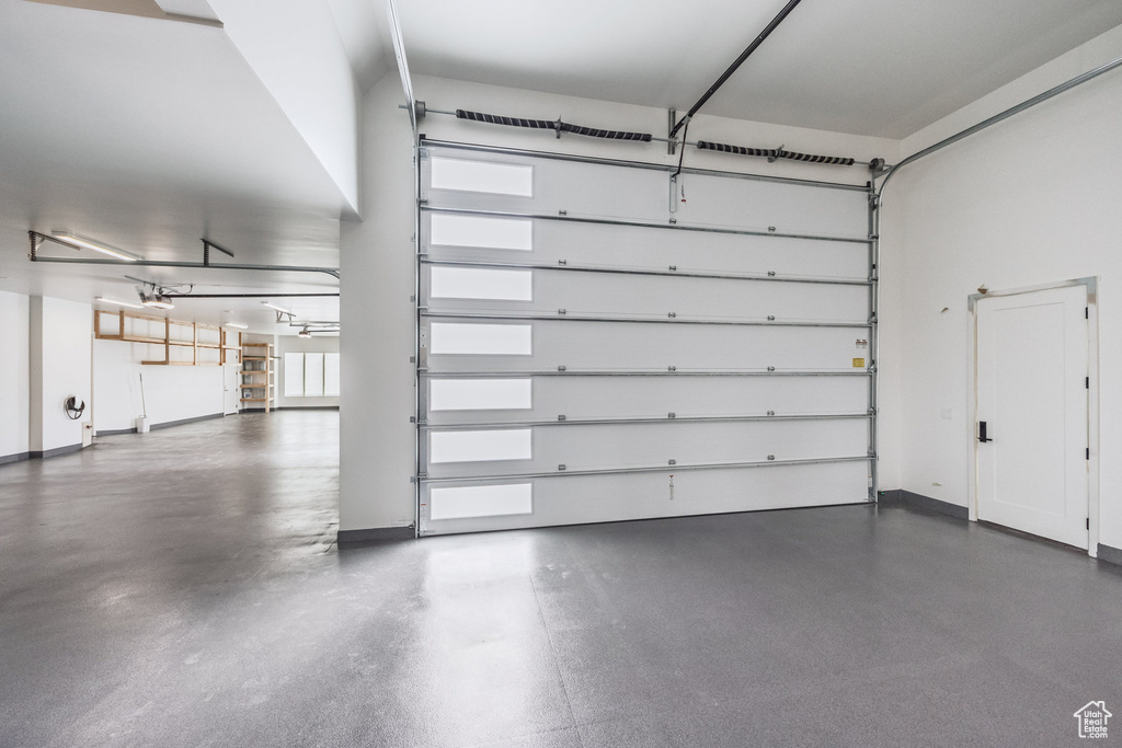 Garage with baseboards and a garage door opener