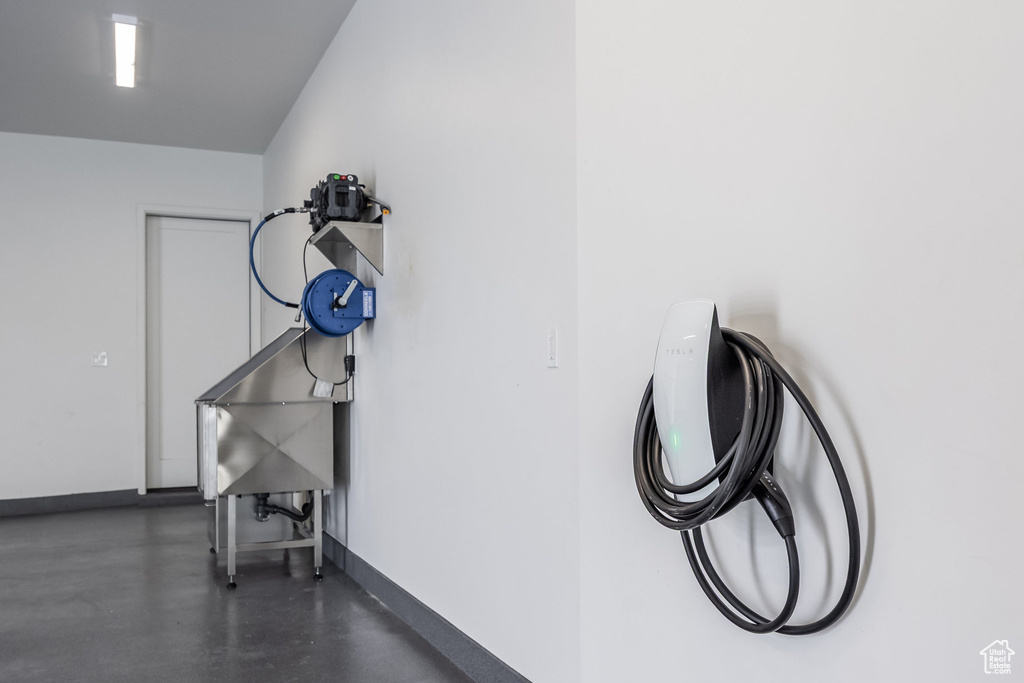 Garage with baseboards and car charger