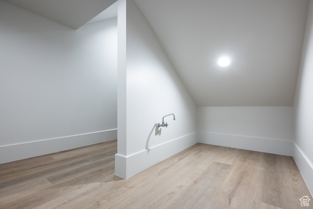 Bonus room featuring baseboards, lofted ceiling, and wood finished floors