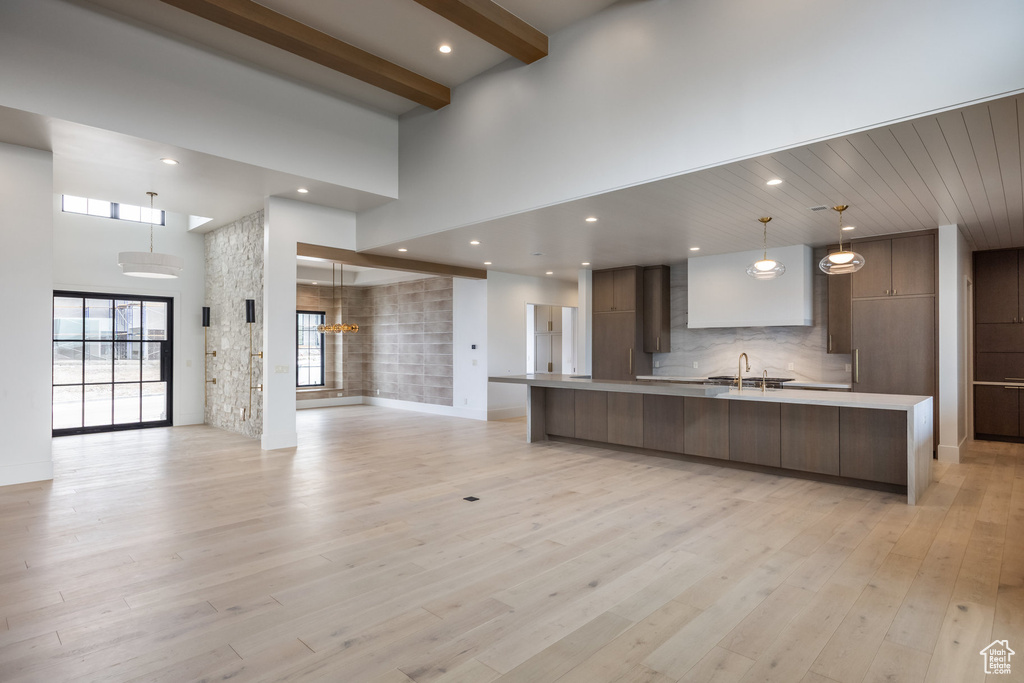 Kitchen featuring modern cabinets, a high ceiling, light countertops, and open floor plan