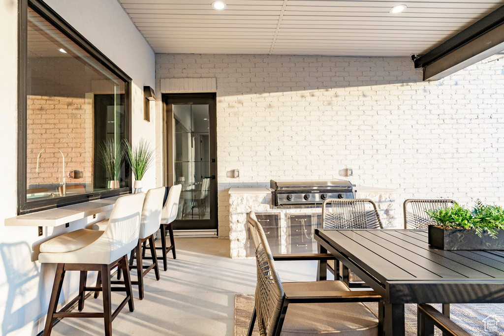 Dining space featuring brick wall, recessed lighting, and light wood-style flooring