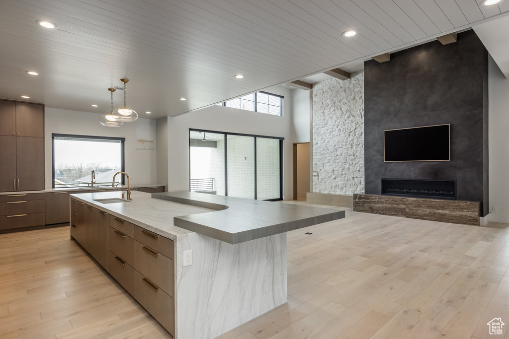 Kitchen with open floor plan, light wood-type flooring, a sink, a wealth of natural light, and modern cabinets