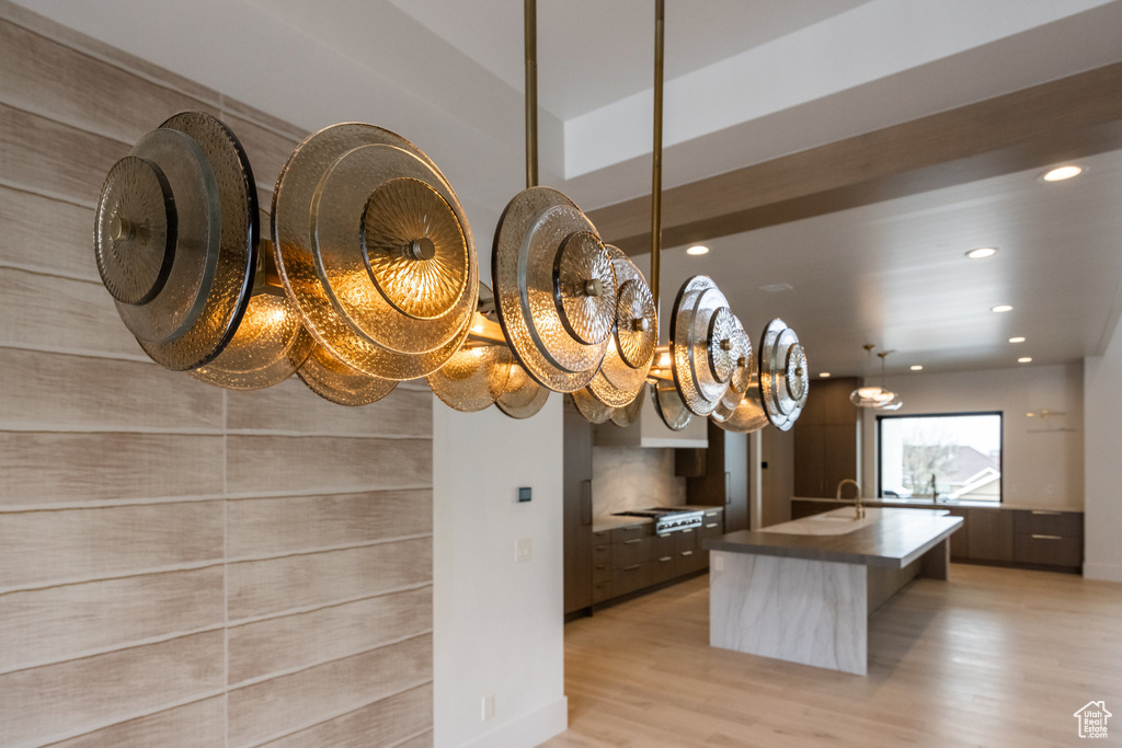 Details featuring a sink, wood finished floors, stainless steel gas stovetop, recessed lighting, and an inviting chandelier