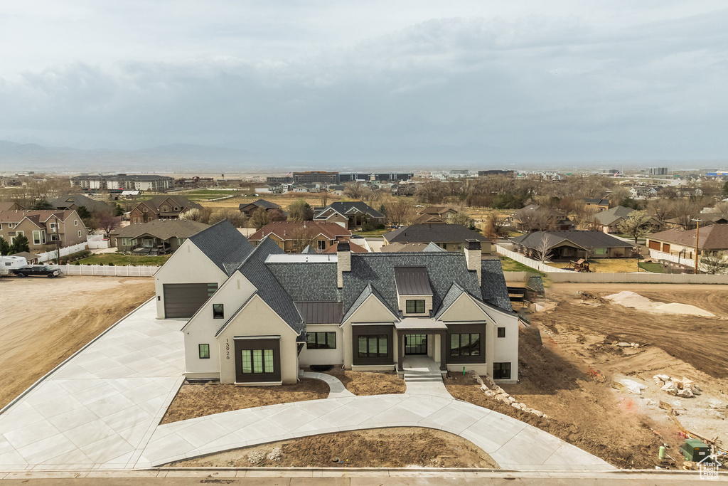 View of front of home featuring driveway, a standing seam roof, stucco siding, a residential view, and metal roof