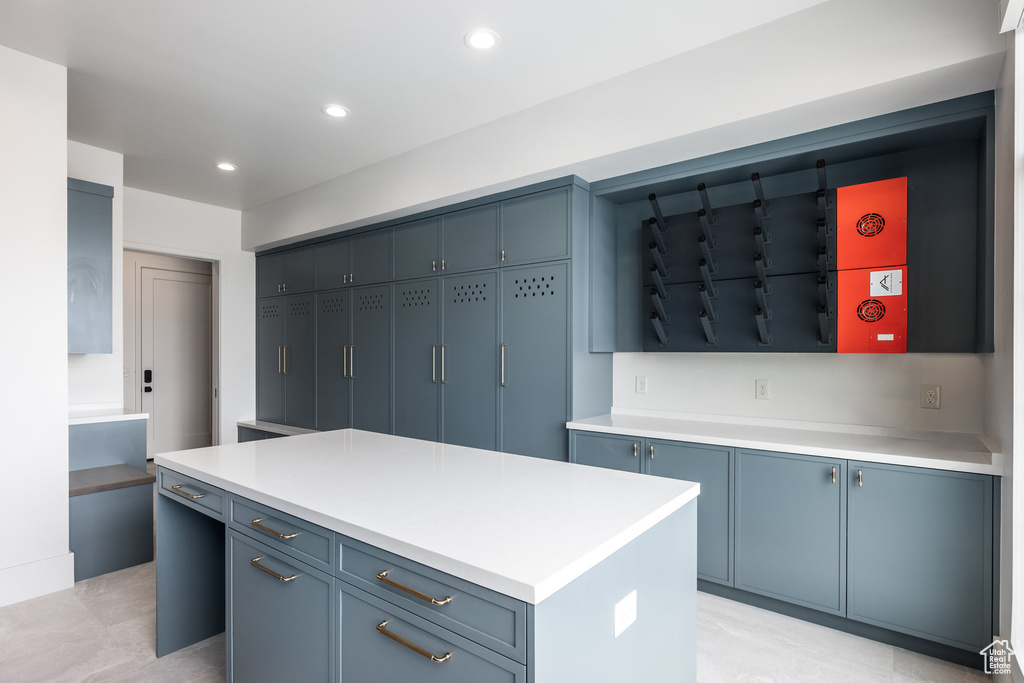 Kitchen featuring blue cabinetry, light countertops, a kitchen island, and recessed lighting