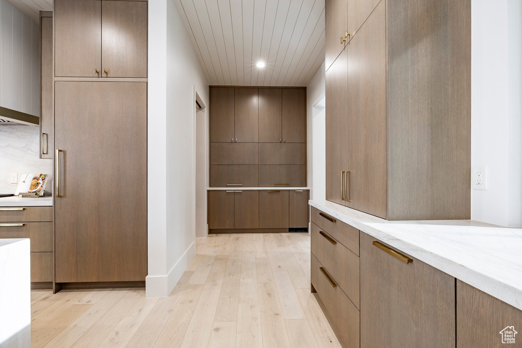 Hallway with light wood-type flooring, recessed lighting, and baseboards
