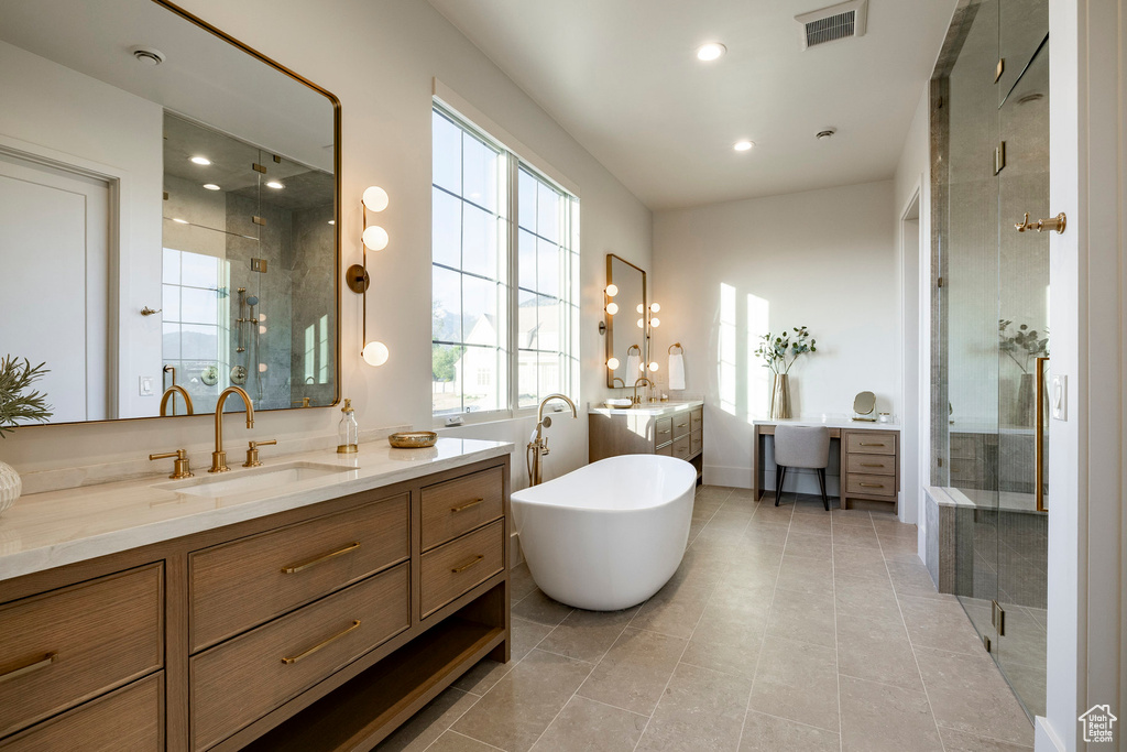 Bathroom with a shower stall, two vanities, a freestanding bath, and recessed lighting