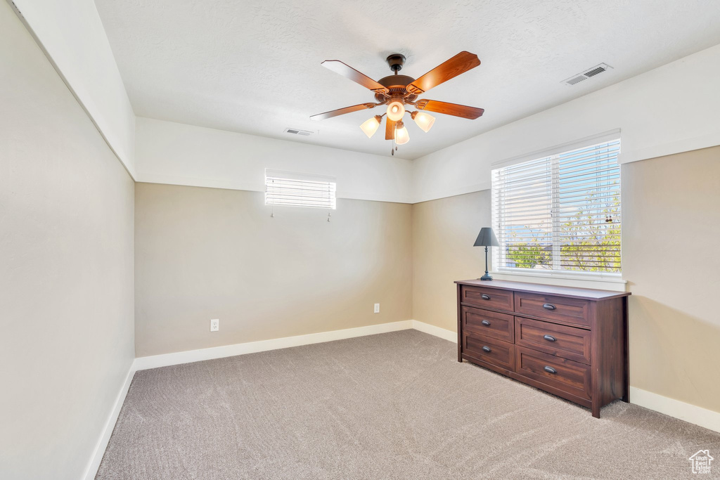 Unfurnished bedroom with light carpet and baseboards