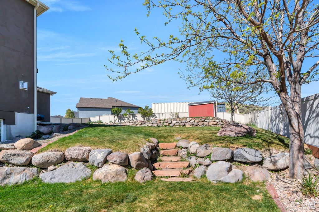 View of yard with a fenced backyard and an outbuilding