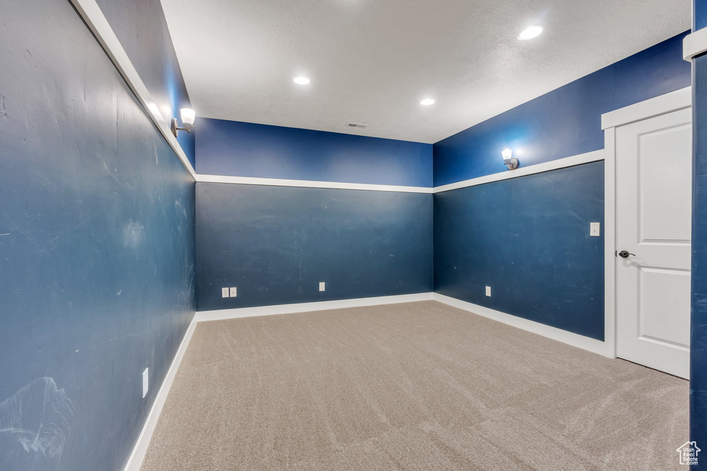 Carpeted empty room with baseboards and recessed lighting