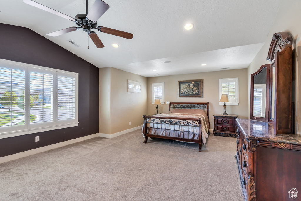 Bedroom with light colored carpet, multiple windows, baseboards, recessed lighting, and vaulted ceiling