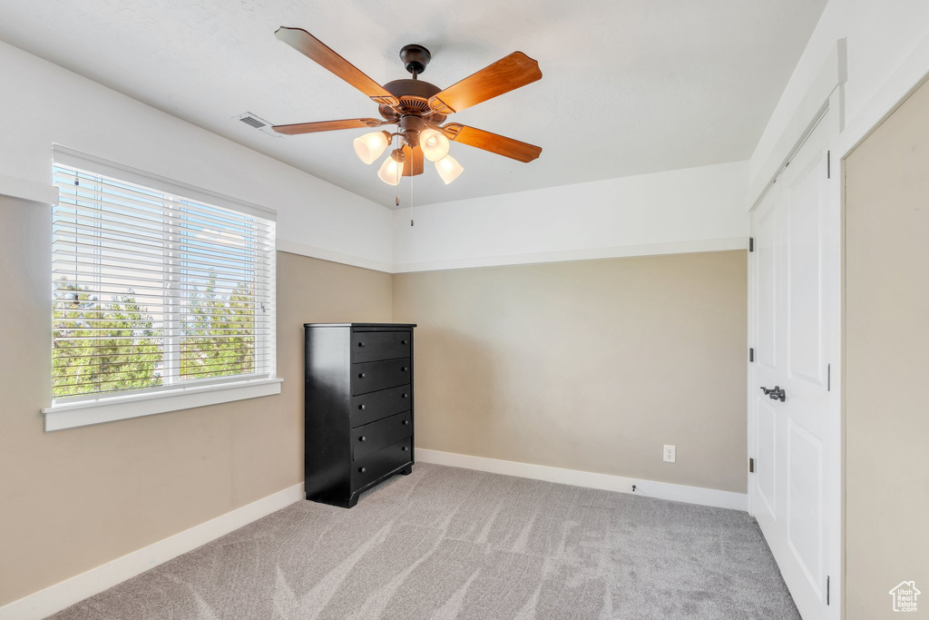 Unfurnished bedroom with carpet, baseboards, and a ceiling fan