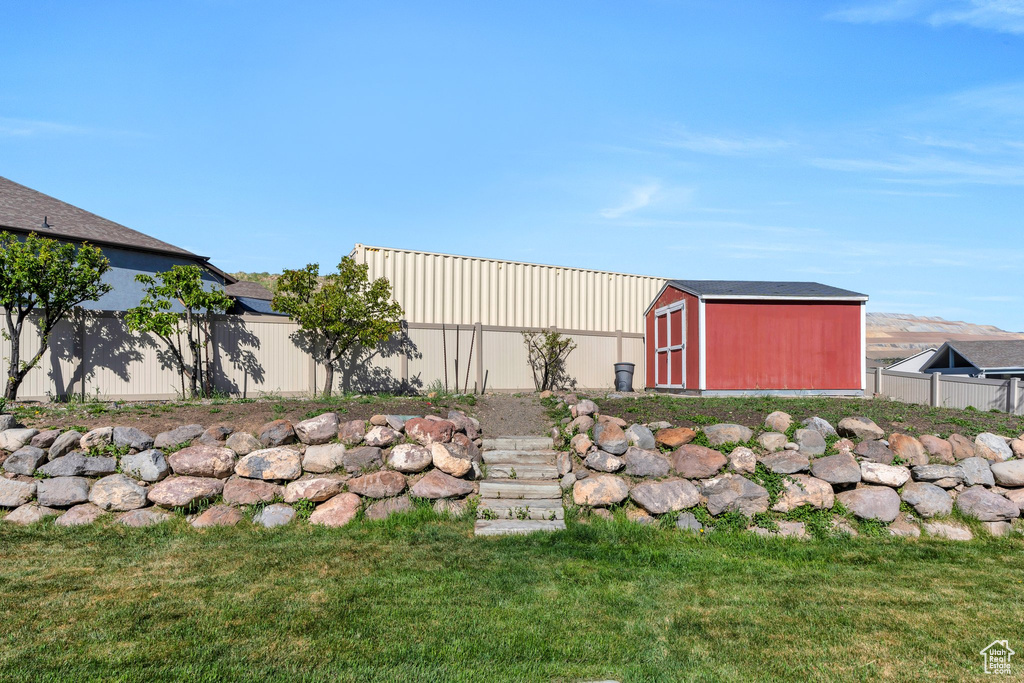 View of yard with an outbuilding, fence, and a storage shed