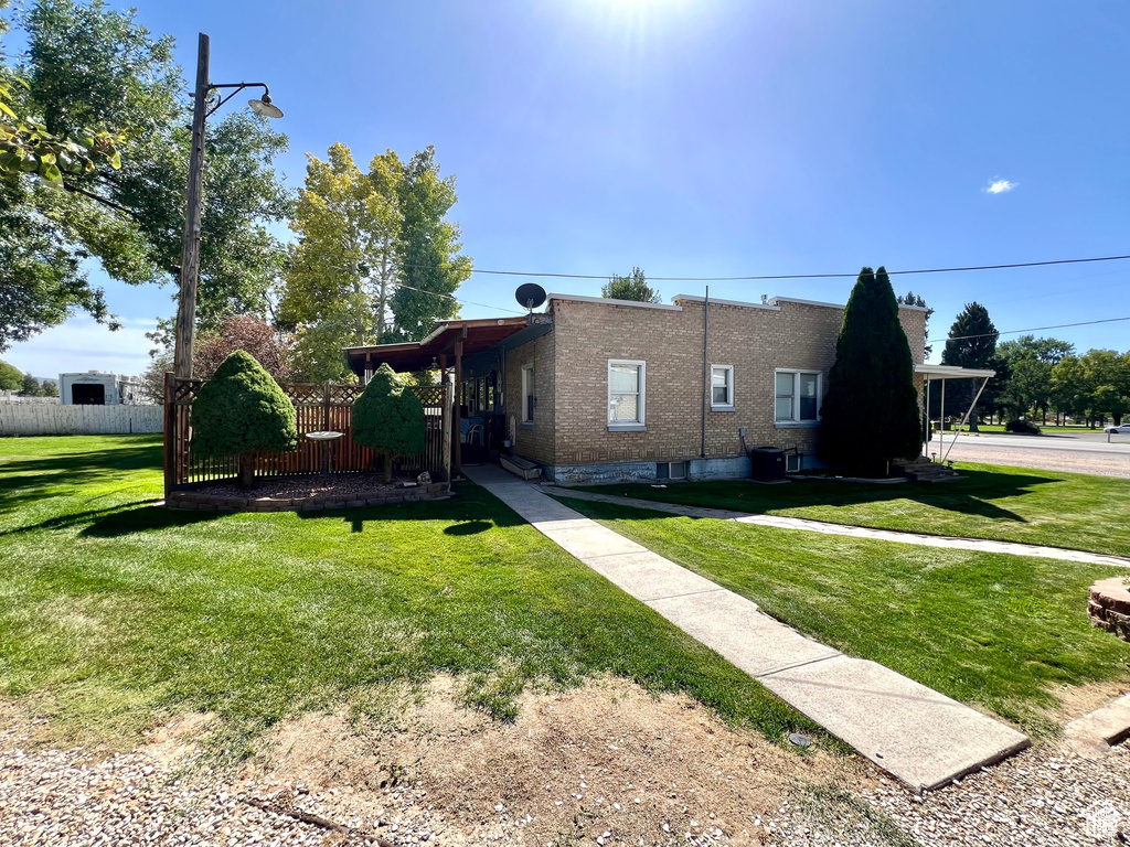 View of front of property featuring brick siding, a front yard, and fence