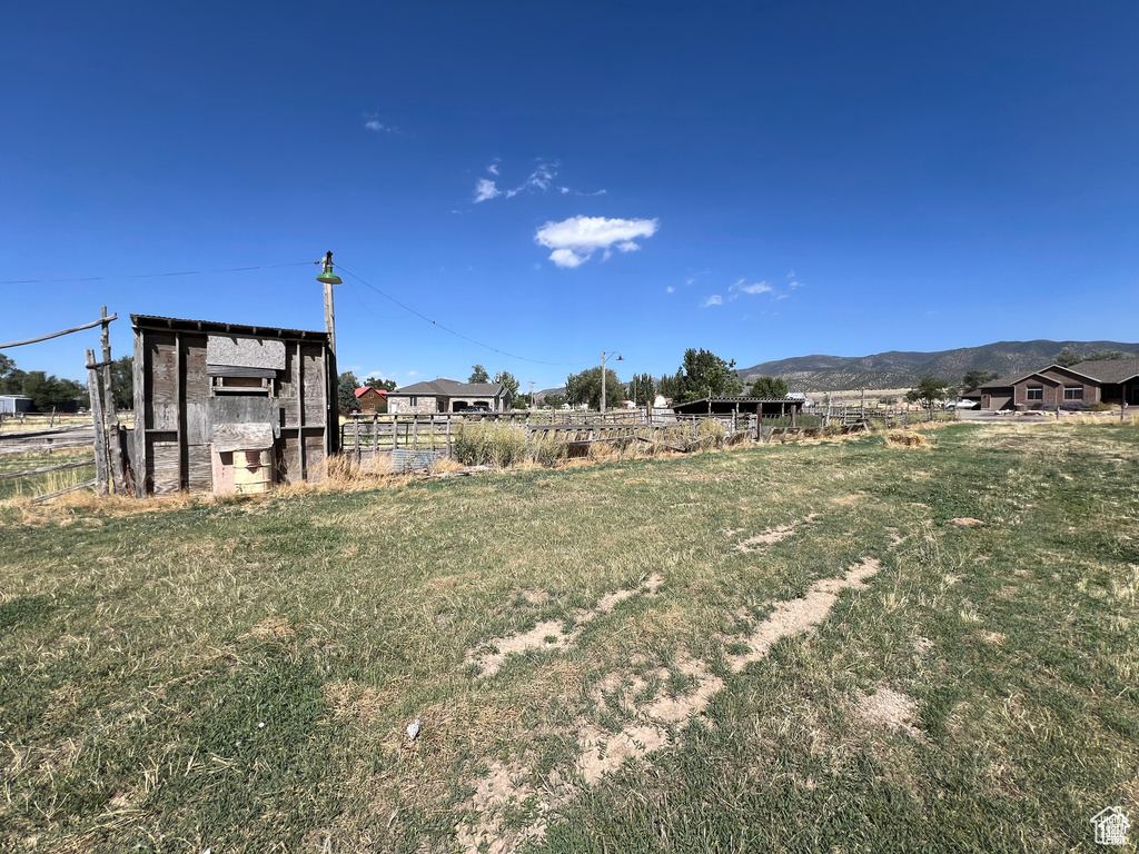 View of yard featuring a mountain view and fence