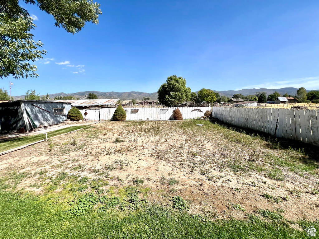 View of yard with a mountain view and fence