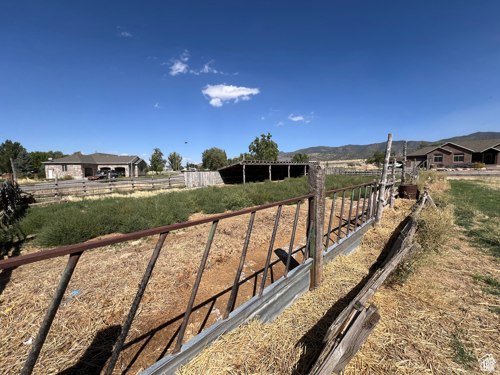 View of yard featuring a mountain view, a rural view, and fence