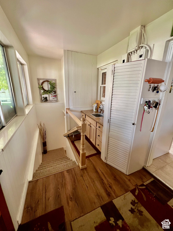 Kitchen with light countertops, a sink, and wood finished floors