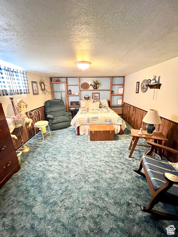 Carpeted living room with a wainscoted wall, wooden walls, and a textured ceiling