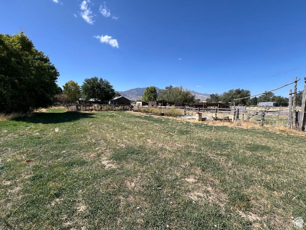 View of yard with a mountain view, fence, and a rural view