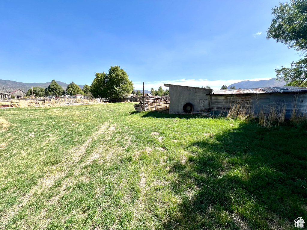 View of yard featuring an outdoor structure, a rural view, and a mountain view