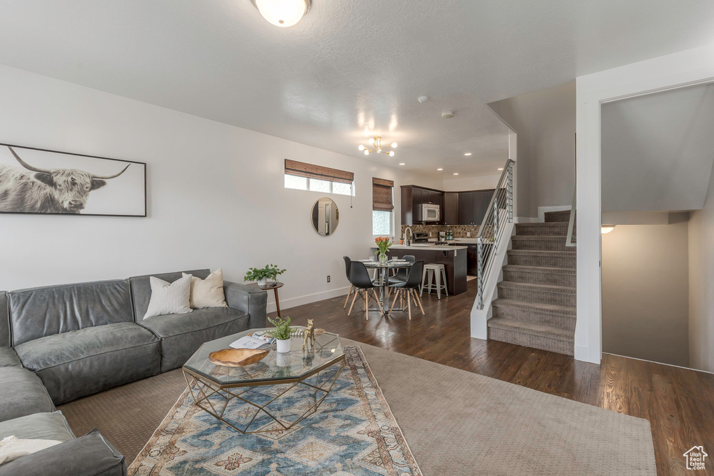 Living area with dark wood-style floors, stairway, and baseboards