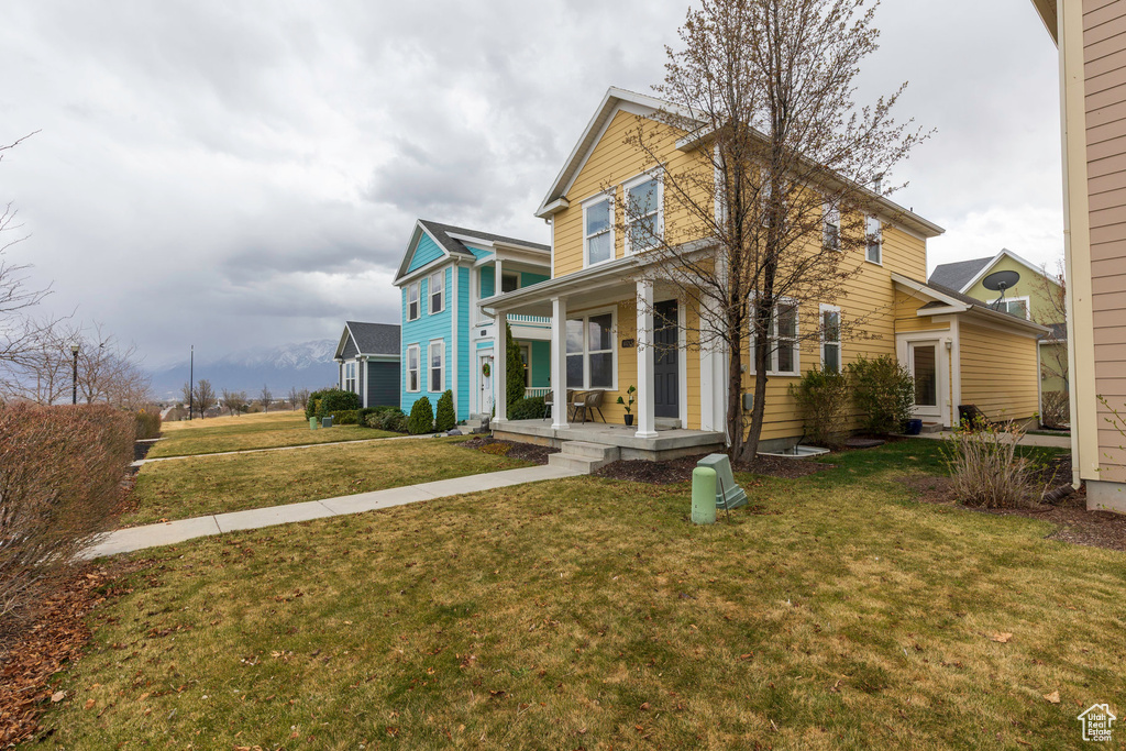 Traditional-style house with a front lawn and covered porch