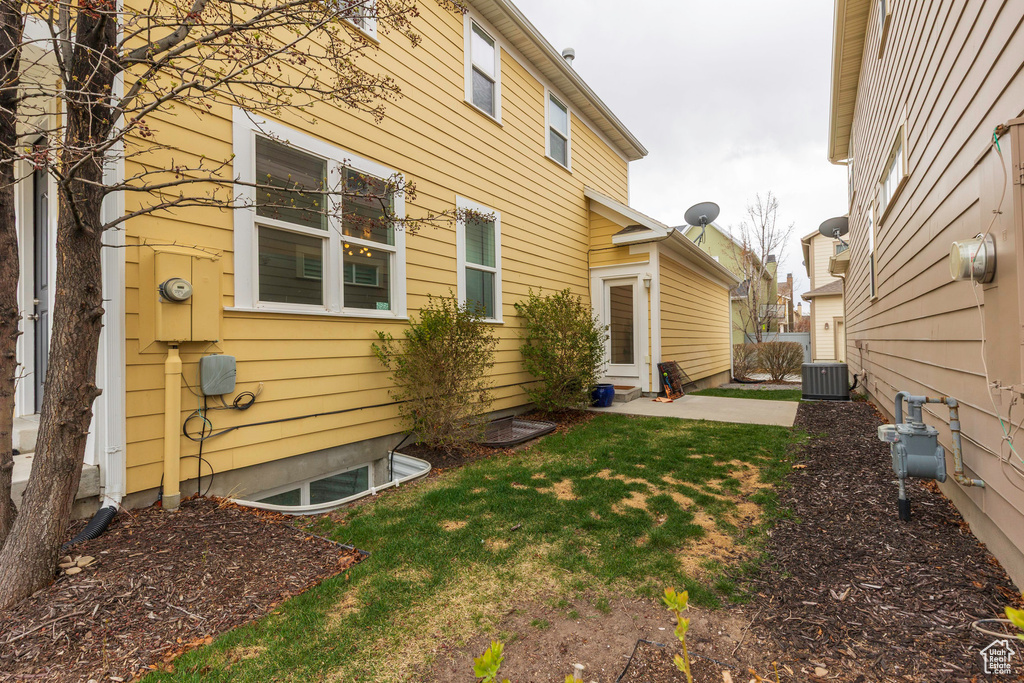 View of home's exterior featuring central air condition unit and a lawn