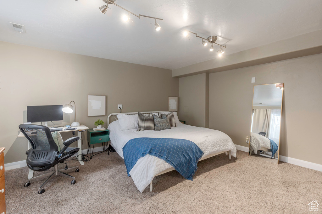 Carpeted bedroom with baseboards and visible vents
