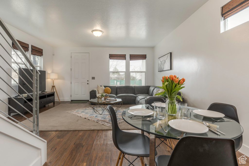 Dining room featuring stairs, wood finished floors, and baseboards