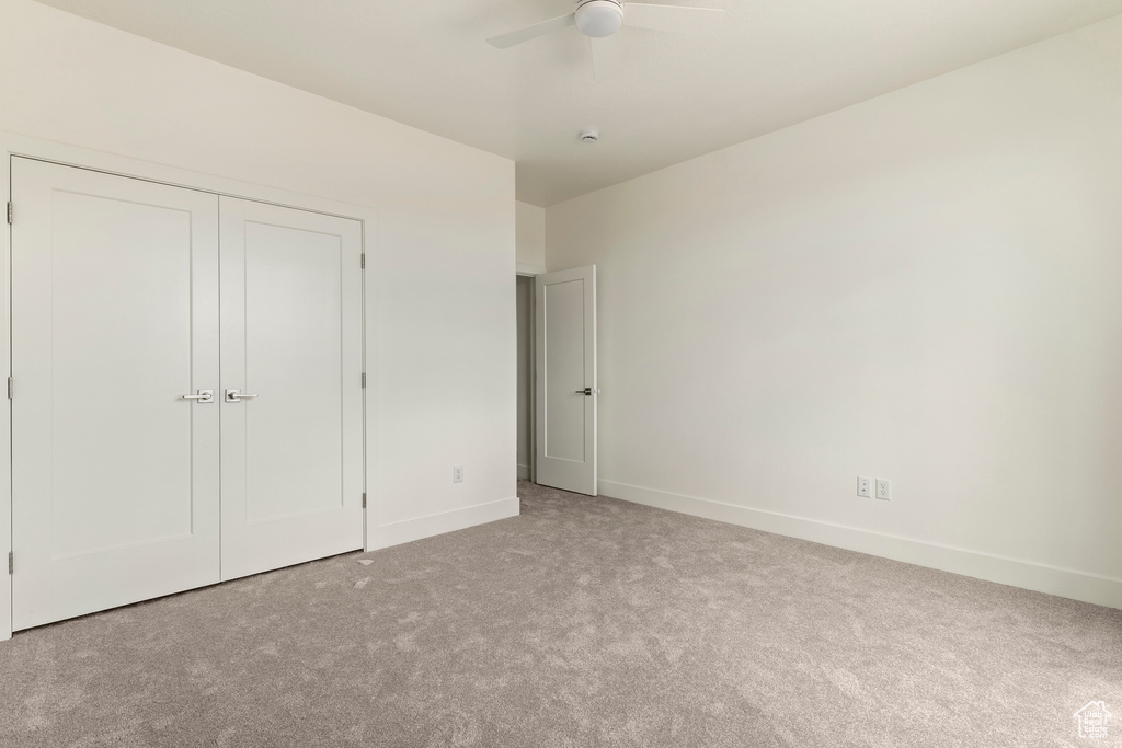 Unfurnished bedroom with carpet flooring, baseboards, a closet, and ceiling fan