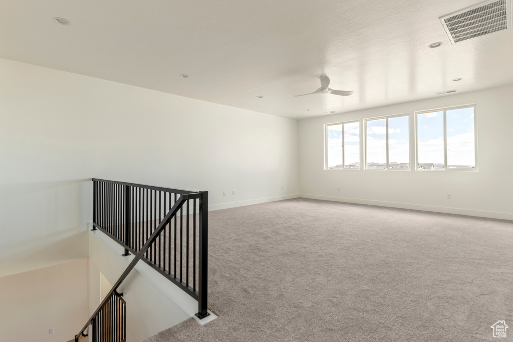 Unfurnished room with carpet floors, baseboards, and ceiling fan