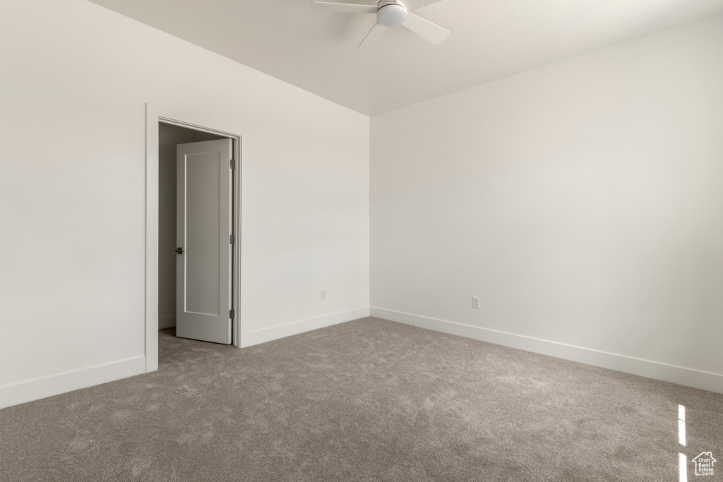 Empty room with carpet, ceiling fan, and baseboards