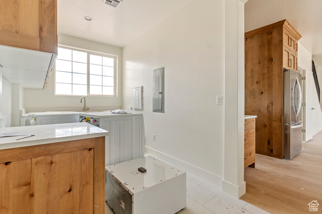 Bathroom with electric panel, baseboards, and wood finished floors