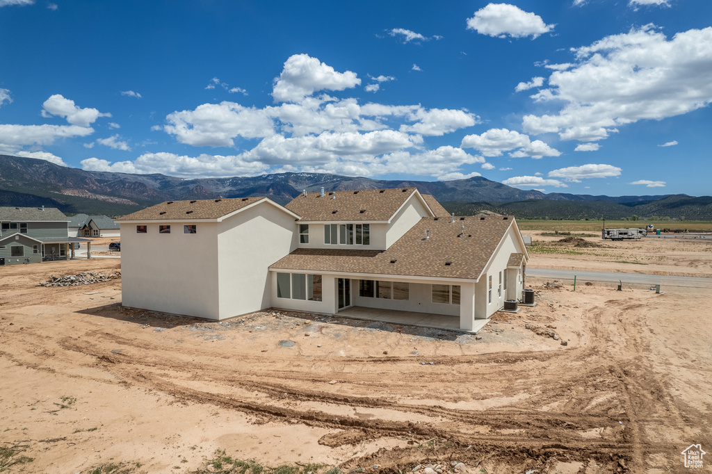 Back of property featuring a mountain view, a patio, and stucco siding