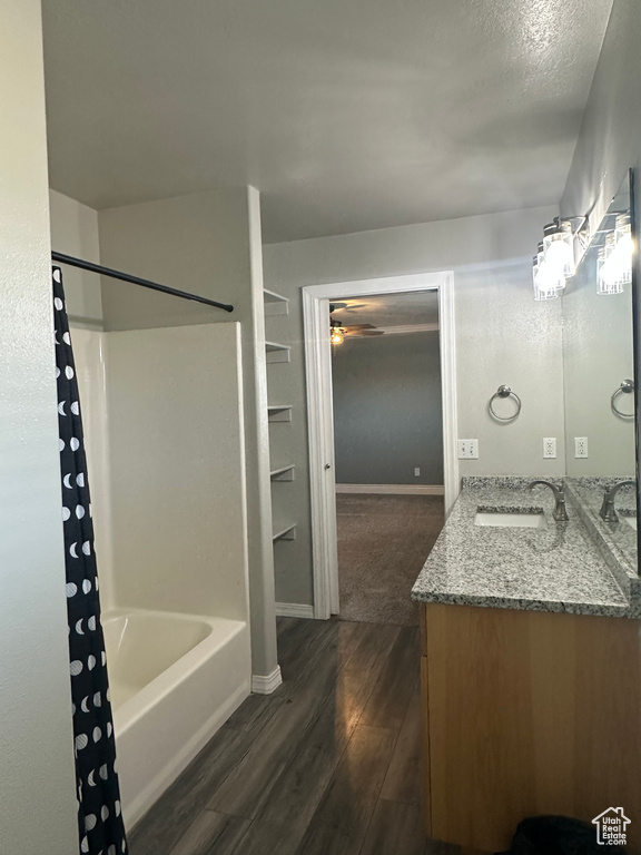 Full bathroom with vanity, baseboards, a ceiling fan, shower / bath combo, and wood finished floors