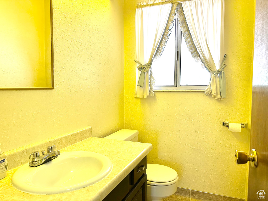 Half bath with vanity and tile patterned flooring