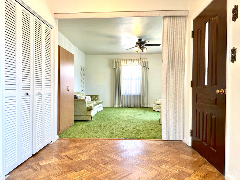 Entryway featuring a ceiling fan and light colored carpet