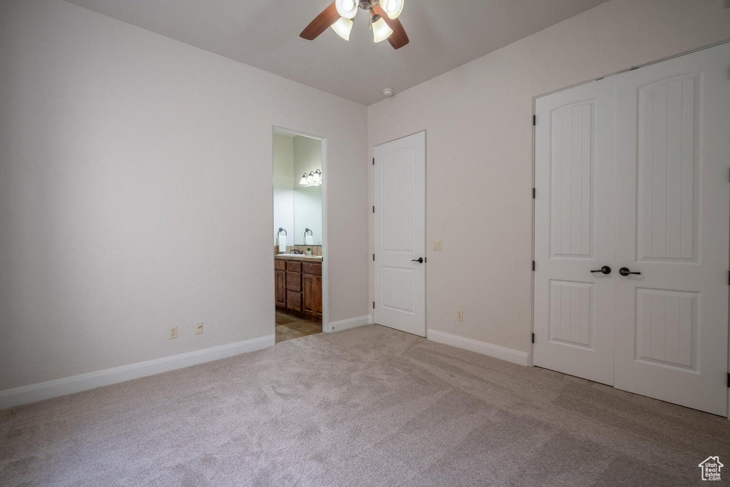 Unfurnished bedroom with baseboards, a ceiling fan, connected bathroom, carpet flooring, and a closet