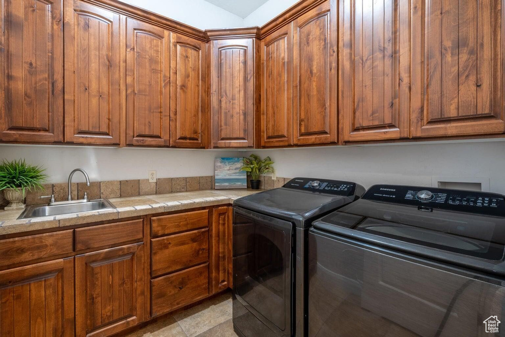 Clothes washing area with cabinet space, washing machine and dryer, and a sink