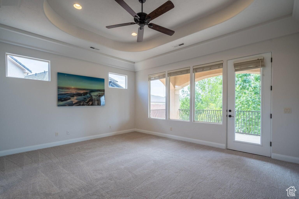 Unfurnished room featuring a raised ceiling, visible vents, and carpet flooring