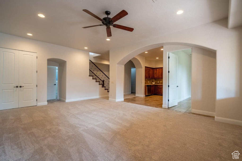 Unfurnished room with recessed lighting, light colored carpet, and stairs